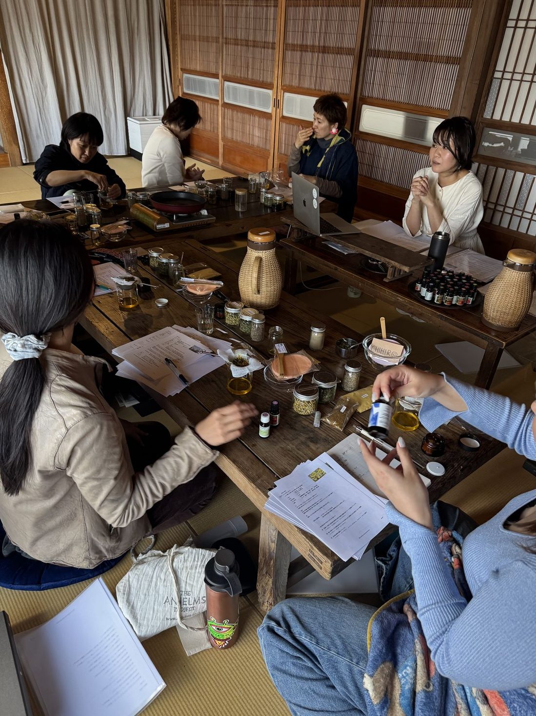 A blending workshop: low wooden tables covered with oils, jars and notes